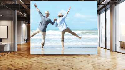 Asian Lifestyle senior couple jumping on the beach happy in love romantic and relax time.  Tourism elderly family travel leisure and activity after retirement in vacations and summer. Wall mural